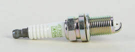 NGK BKR5EGP spark plug showing metal terminal and ceramic insulator for automotive engine ignition system.