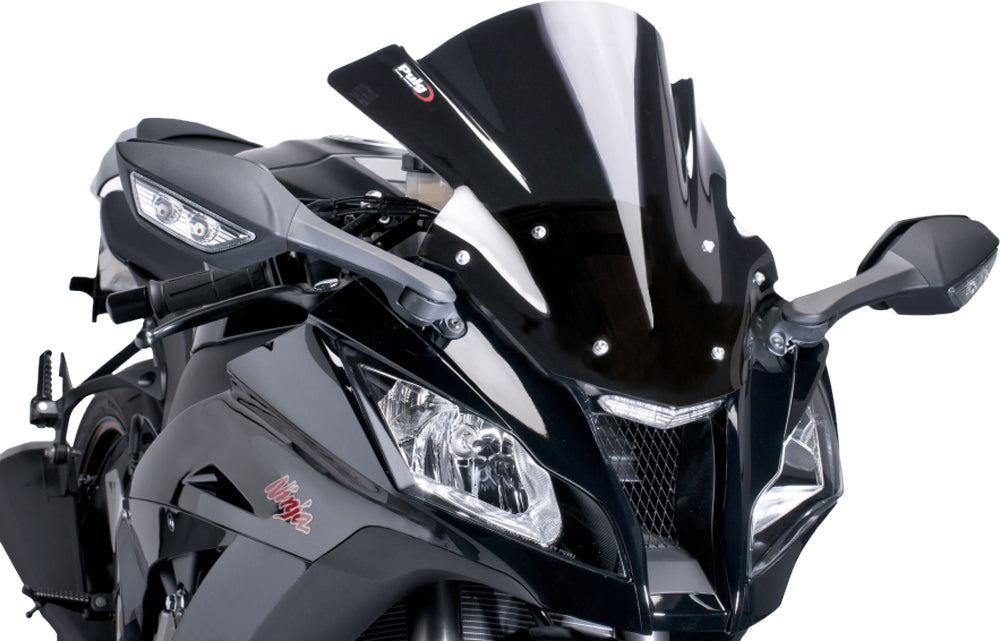 Black PUIG racing windshield with aerodynamic design, mounted on a motorcycle, showcasing its sleek, high-performance appearance.