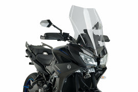 Clear PUIG touring windshield mounted on a motorcycle, providing wind protection with a sleek, aerodynamic design.