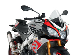 Clear PUIG racing windscreen for motorcycle, shown mounted on the bike with a streamlined design and smooth edges.