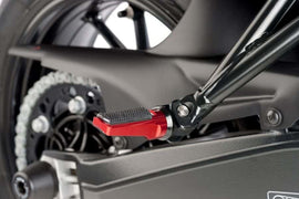 Red PUIG sport footpegs for motorcycle foot controls, with detailed metal design and mounting brackets visible.