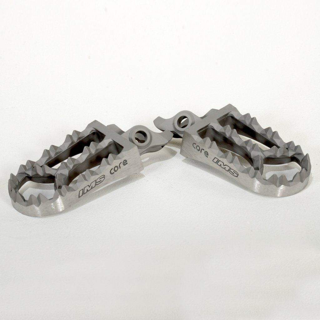 IMS Core Enduro Footpegs for motorcycle foot controls, featuring durable metal construction and textured surface for grip.
