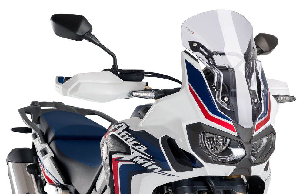 Clear PUIG racing windscreen for motorcycle, aerodynamic windshield with mounting edges and reflective surface.
