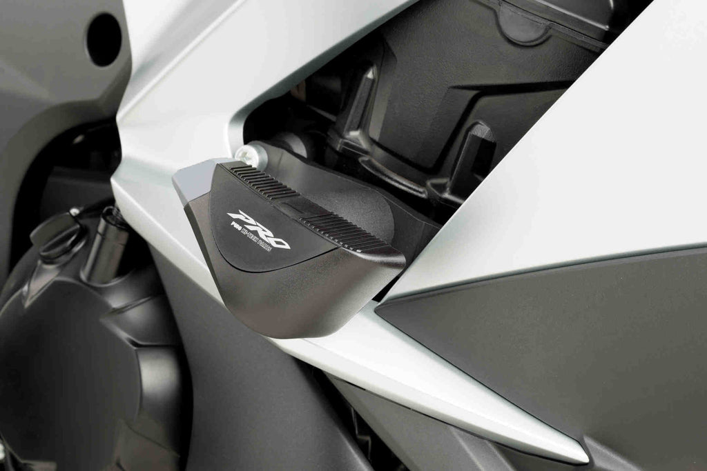 Black PUIG Frame Sliders Pro for Kawasaki motorcycle, mounted on body frame, designed for protection and style.