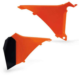 Acerbis orange airbox cover for motorcycle, showing close-up of the durable plastic part with brand logo and textured surface.