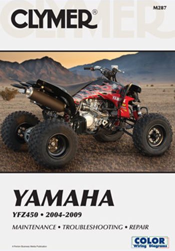 Clymer repair manual for Yamaha YFZ450 27-M287, showing detailed technical diagrams and repair instructions open on a table.
