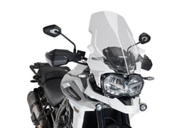 Clear PUIG touring windshield for motorcycle, showing the transparent windscreen with mounting edges and smooth curved design.