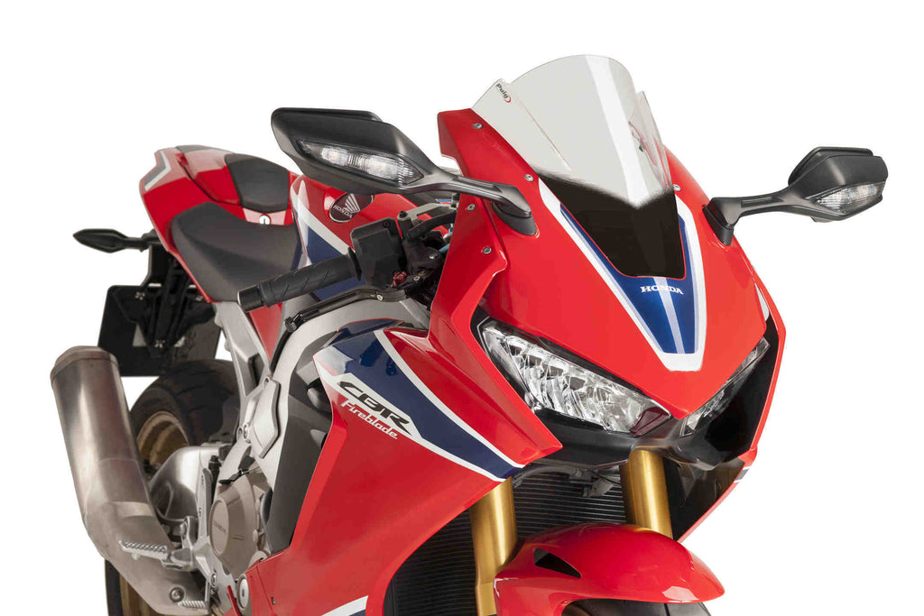 Clear PUIG racing windscreen for motorcycle, aerodynamic windshield with mounting hardware, designed for high-performance riding.