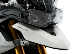 Clear PUIG headlight protector for Tri motorcycles, shows a close-up of the transparent shield fitting over the headlight.