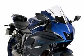 Clear PUIG racing windshield for Yamaha motorcycle, durable windscreen with mounting hardware visible in the image.