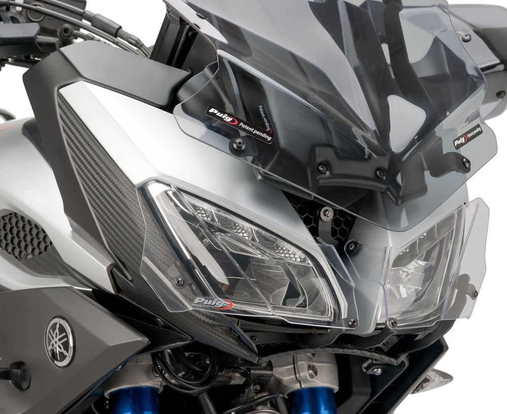 PUIG headlight protector body for motorcycle, made of durable material, shown installed on the vehicle's headlight area.