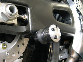 Black Shogun Industries Swingarm Sliders for motorcycle, mounted on the body of the bike, with visible mounting hardware.