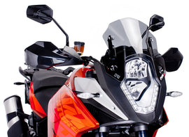 PUIG Racing Light Windscreen for motorcycle, clear windshield with aerodynamic design, mounted on bike with mounting brackets.