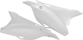 Acerbis white side panels for motorcycle, shown with their smooth, glossy surface and mounting points for installation.