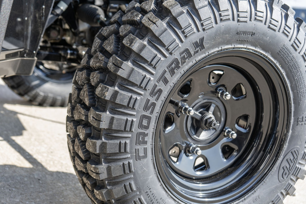 ITP Tire Crosstrax 27x11R-14 8-ply radial tire with rugged tread pattern for off-road use, shown on a vehicle wheel.