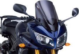 PUIG racing dark smoke windshield showing sleek tinted design and aerodynamic shape for motorcycle protection