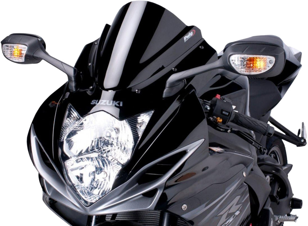 Clear PUIG racing windscreen for motorcycle, showing its curved design and transparent acrylic material.