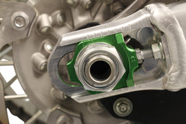 WORKS Axle Blocks Elite Kaw/Suz green drive axle blocks for motorcycle wheel alignment and stabilization.