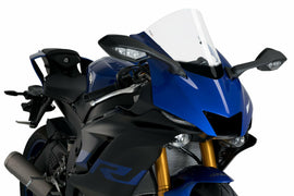 Clear PUIG windscreen for R-Racer motorcycle, showing lightweight, transparent windshield with mounting edges.
