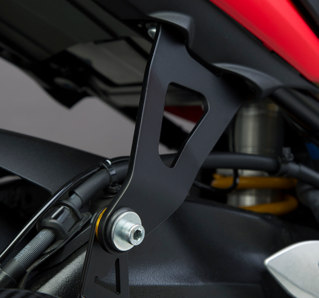 Yoshimura muffler bracket for GSXS1000F motorcycle, shown in black with mounting hardware attached.