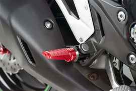Red PUIG racing footpegs for motorcycle foot controls, featuring durable metal construction and a textured grip surface.