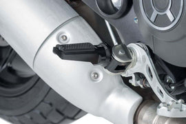 Black PUIG Sport footpegs for motorcycle foot controls, showing textured surface and mounting points for secure grip.