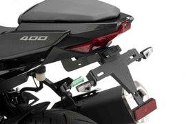 Black PUIG Fender Eliminator Kit for Kawasaki motorcycle, showing sleek body design and mounting hardware in close-up image.