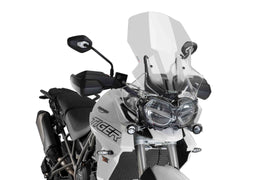 Clear PUIG touring windscreen, aerodynamic motorcycle windshield with mounting hardware, designed for enhanced ride comfort.