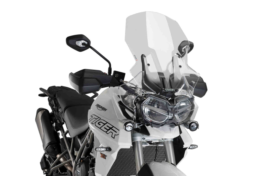 Clear PUIG touring windscreen for motorcycle, showcasing its curved design and mounting points for enhanced wind protection.