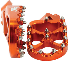 Flo Motorsports Pro Series orange foot pegs for KTM and Husqvarna bikes, featuring durable metal construction and textured surface
