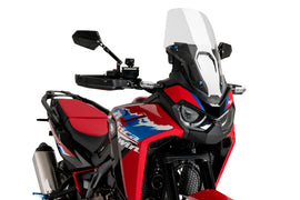 Clear PUIG touring windscreen for motorcycle, showcasing its transparent, curved design ideal for wind protection.