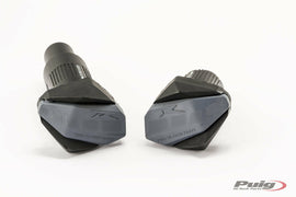 PUIG R12 black frame sliders for Suzuki motorcycle, body protection parts with mounting hardware, on a black background.