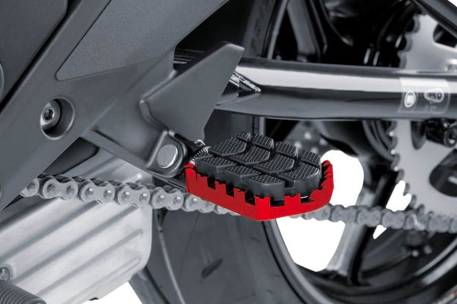 Red PUIG Enduro footpegs for motorcycle foot controls, featuring durable metal construction with textured surfaces for grip.