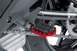 Red PUIG Enduro footpegs for motorcycle foot controls, featuring durable metal construction with textured surfaces for grip.