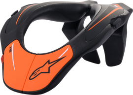 Alpine Star youth neck support in black and orange, designed for safety and comfort during sports or outdoor activities.