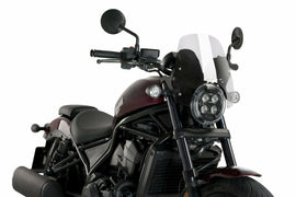 Clear PUIG Nng Sport motorcycle windshield showing sleek, aerodynamic design with mounting points against a neutral background.