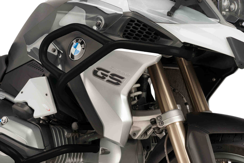 Black PUIG engine guards for BMW motorcycle, mounted on the engine body, with a sleek protective design.