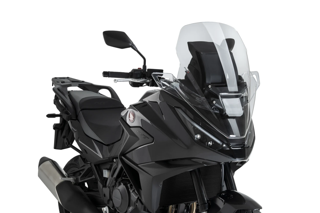 Clear PUIG touring windshield for motorcycle, showcasing its transparent, aerodynamic design and mounting edges.